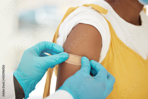 Covid  vaccine and bandaid on the arm of a black woman patient in a hospital for an injection or healthcare. Doctor  medical and insurance with a female in a clinc for her corona virus vaccination