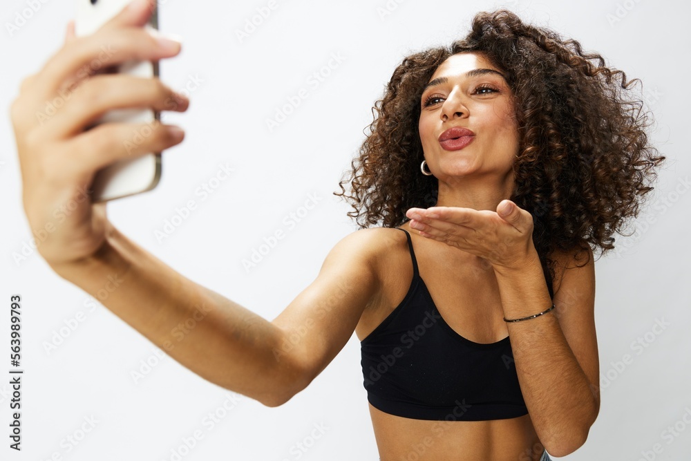 Woman blogger with phone in hand on white background selfies, video call, freelancer influencer job in social media and media, technology for work, smile curly hair copy spot