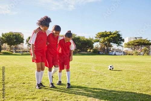 Children, soccer and girl team help, support and walking with injured friend at soccer field. Sports injury, kids and football player group helping, holding and carrying player for football accident