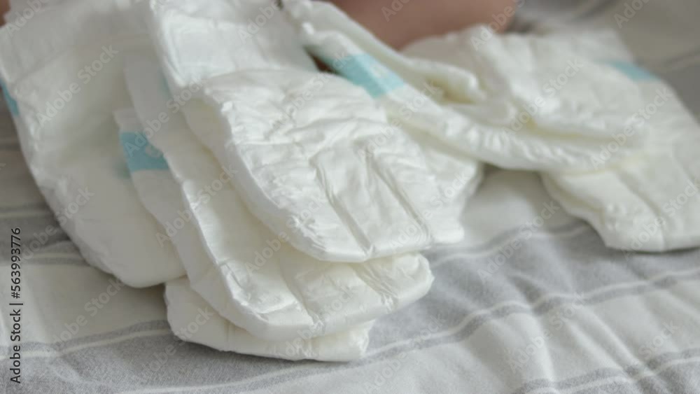 baby diapers in pack woman mother hand or bed finger counting throwing on blanket chaotic or in row arrangment.mom hand hold new diaper white no paint drawn close up 4k slow motion motherhood baby diapers in pack woman mother hand or bed finger counting throwing on blanket chaotic or in row arrangment.mom hand hold new diaper white no paint drawn close up 4k slow motion motherhood