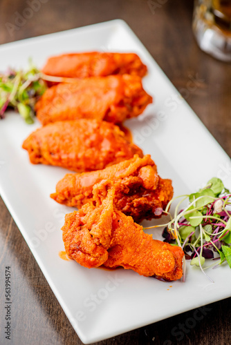 
Chicken wings. Buffalo chicken wings. American cuisine of chicken wings deep-fried, dipped in buffalo sauce made of vinegar,  cayenne hot sauce and butter. Served with celery, carrots, blue cheese.