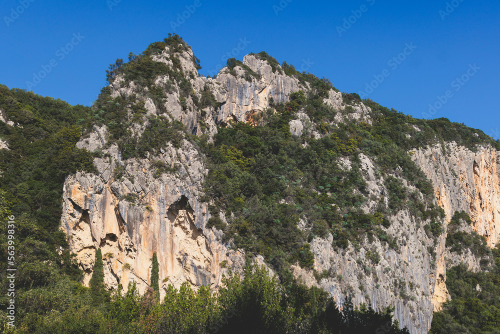 View of hiking trail from Paleokastritsa to Lakones, Old Donkey path, Corfu, Kerkyra, Greece, Ionian sea islands, with olive grove forest and mountains, in a summer sunny day, trekking on Corfu