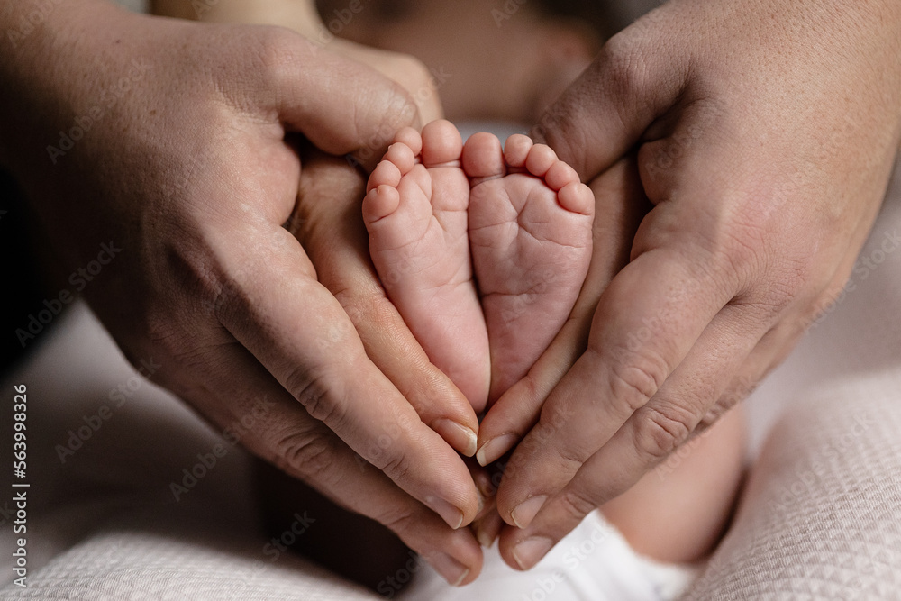 newborn baby feet on mom and dad hands. happy family concept newborn baby feet on mom and dad hands. happy family concept
