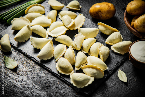 Potato dumplings on a stone board with green onions. 