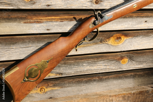 Stock of a traditional black powder Kentucky rifle on an old, damaged board