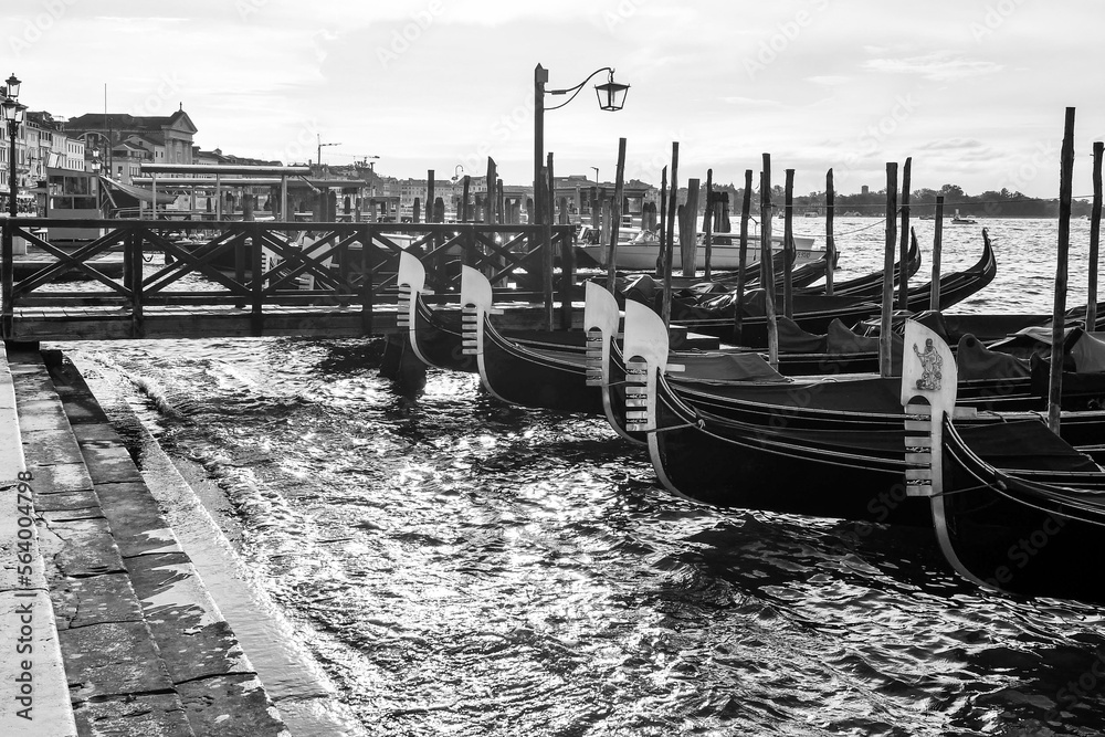 Row of gondolas moored at Riva degli Schiavoni quay, (black and white), Venice, Italy