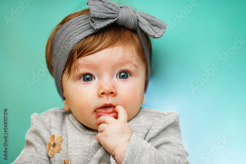 Portrait of little baby girl in a gray dress
