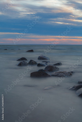 Rocky shore of Baltic sea at sunset, sky is full of clouds, blue mood, long exposure. Viimsi, Estonia © yegorov_nick