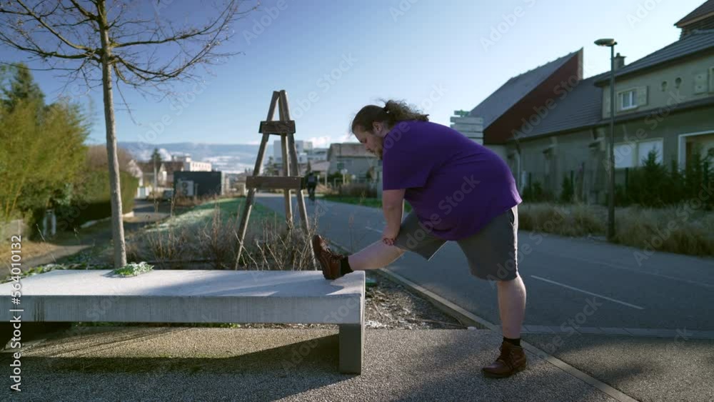 One overweight man stretching legs preparing to exercise outdoors. An active fat chubby guy workout. Getting back into fitness concept One overweight man stretching legs preparing to exercise outdoors. An active fat chubby guy workout. Getting back into fitness concept