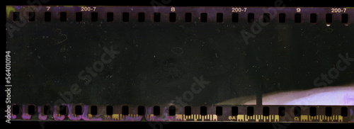 underexposed 35mm film strip on black background with smear marks, scratches and dust. photo
