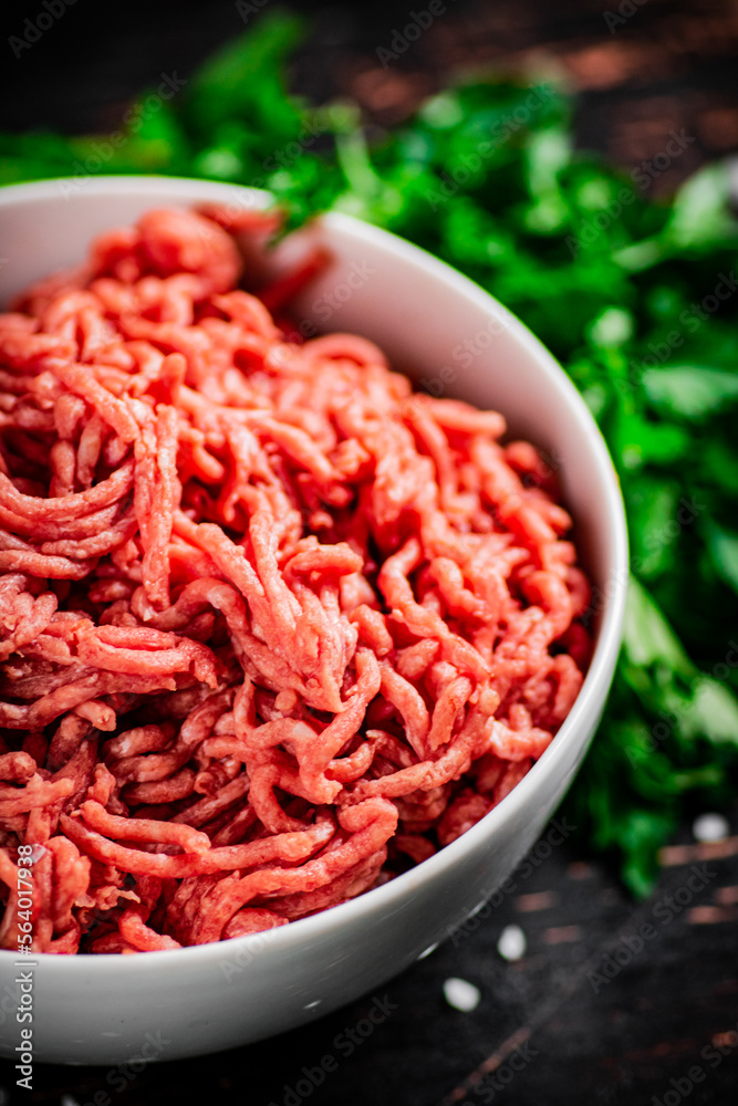 Minced fresh meat in a bowl with parsley. Minced fresh meat in a bowl with parsley.