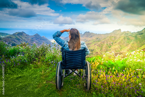 Foto Disabled handicapped woman in wheelchair on mountain hill enjoying view