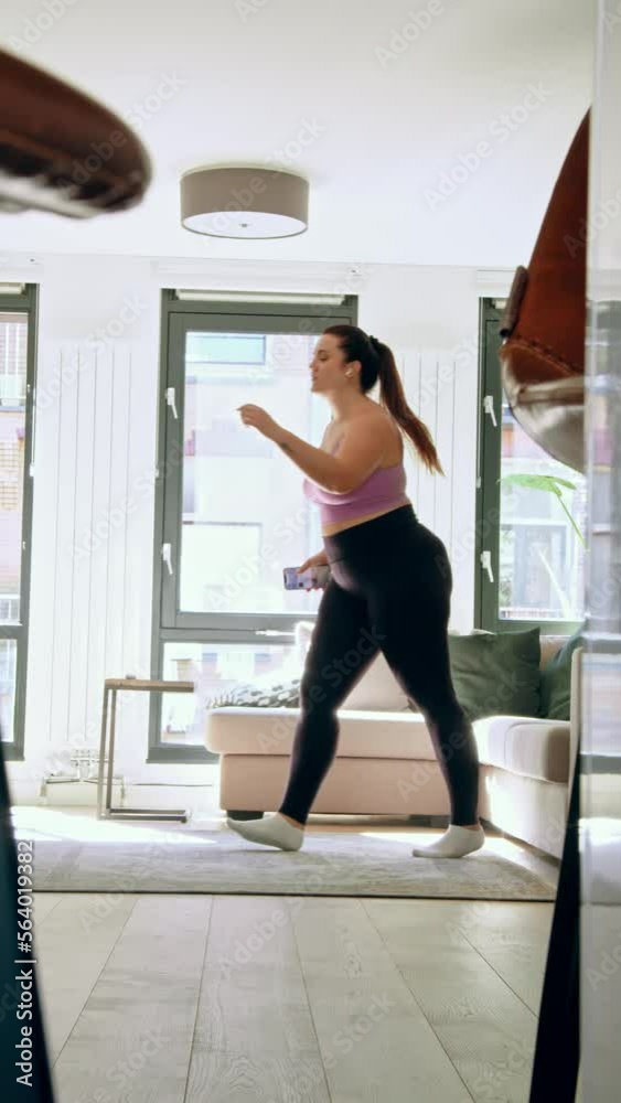 Vertical view of the body positive woman jumping at home at the floor Vertical view of the body positive woman jumping at home at the floor