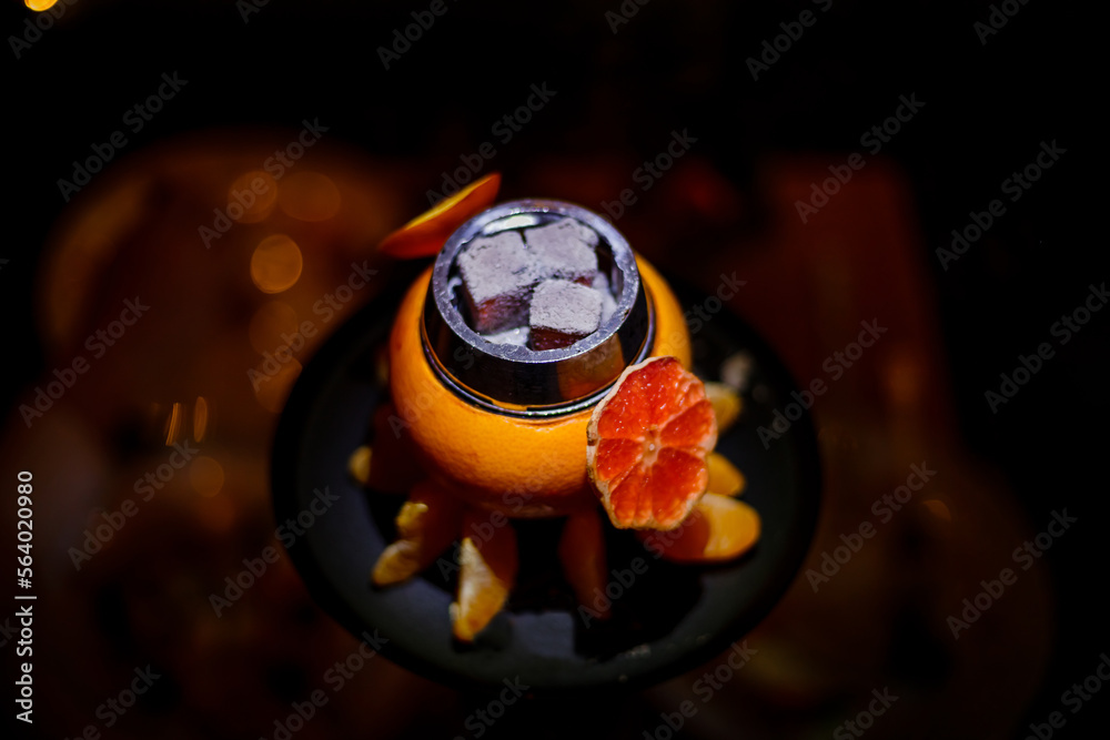 Hookah on orange with smoke, with tangerine slices . High quality photo. Close-up photo