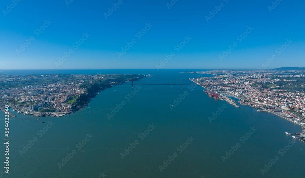 The 25 April bridge (Ponte 25 de Abril) located in Lisbon, Portugal, crossing the Targus river. Drone.