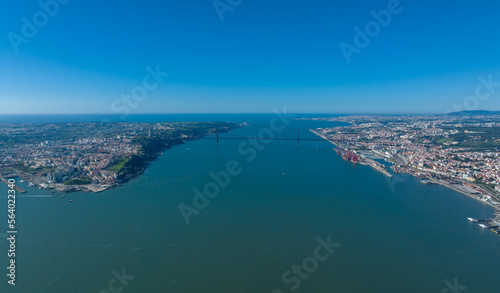 The 25 April bridge (Ponte 25 de Abril) located in Lisbon, Portugal, crossing the Targus river. Drone.