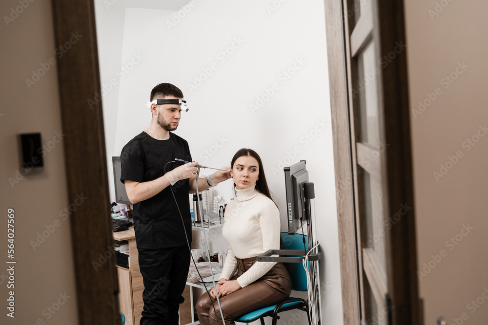 Ear endoscopy. Ears endoscopy procedure with endoscope. ENT doctor otolaryngologist with headlight treat ears of girl patient. Ear endoscopy. Ears endoscopy procedure with endoscope. ENT doctor otolaryngologist with headlight treat ears of girl patient.