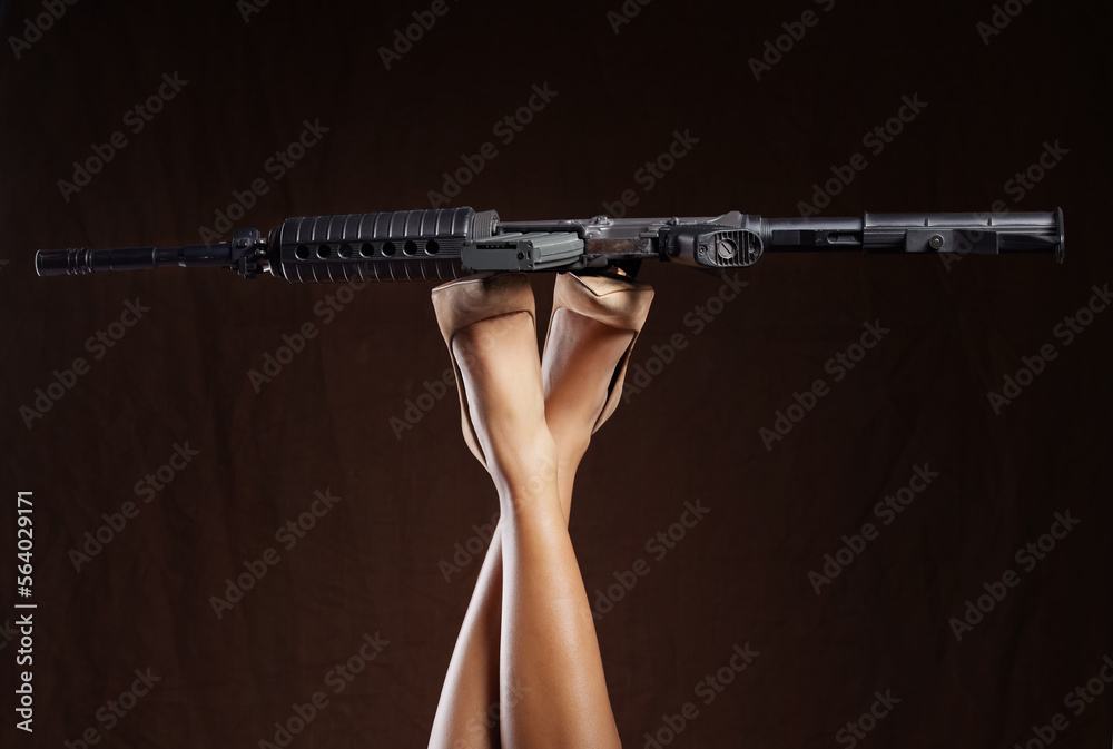 Mafia, criminal and legs of a woman with a gun isolated on a black background in a studio. War, army and feet of a person in heels with a revolver for violence, crime and shooting on a dark backdrop