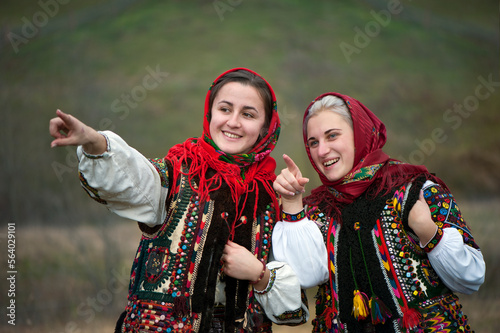 Young girls dressed in ancient picturesque Hutsul national clothes looking for handsome guys. Ukraine.
