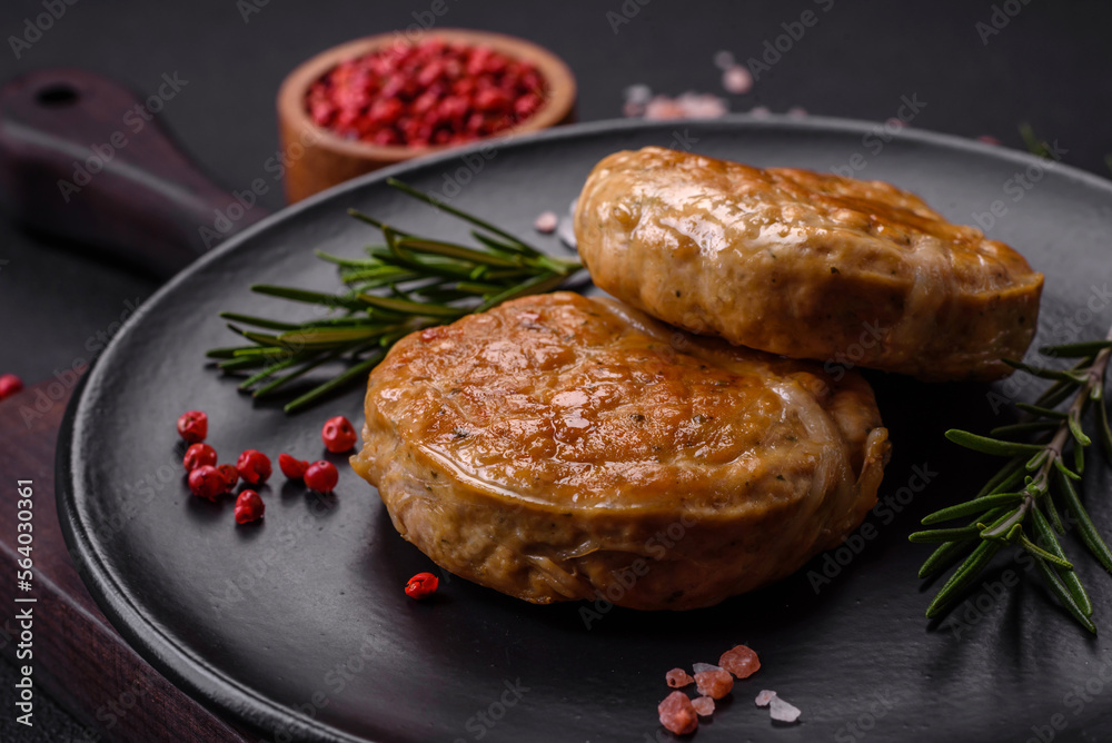 Grilled meatballs with spices and herbs or crepinette on a black plate Grilled meatballs with spices and herbs or crepinette on a black plate