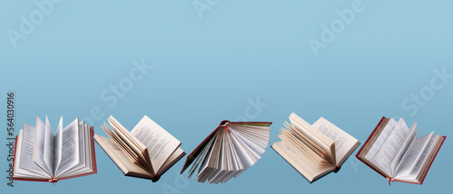 open books and textbooks fly on a blue background, copy space
