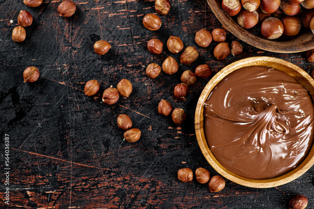 Hazelnut butter and inshell hazelnuts on the table in plates. Hazelnut butter and inshell hazelnuts on the table in plates.