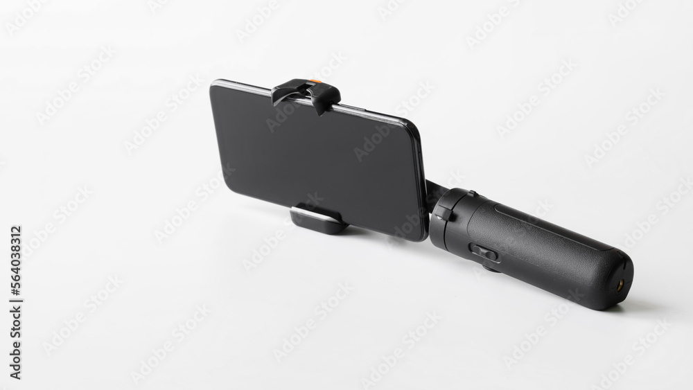 Modern mobile phone mounted on a gimbal to stabilize photo-video shooting and eliminate camera shake. White background. Modern mobile phone mounted on a gimbal to stabilize photo-video shooting and eliminate camera shake. White background.