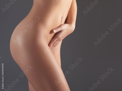 Naked, woman and cosmetics for body, dermatology and natural beauty on grey studio background. Female with nudity, lady and nude with confidence, wellness and stomach with smooth and clear skin photo