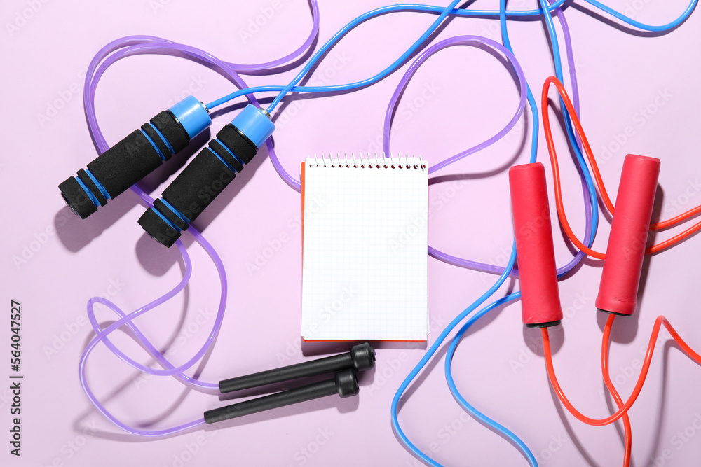 Blank notebook with skipping ropes on pink background