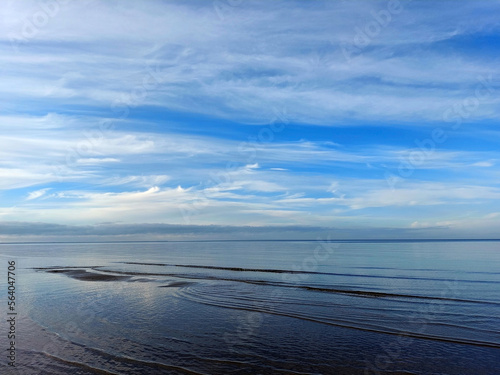 Calm sea and blue sky with fluffy white clouds. Neutral background.