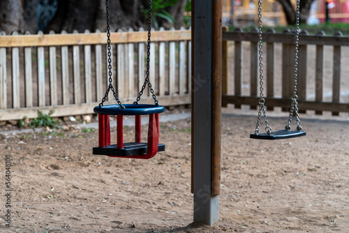 Children's playground in the park. Empty swing in the wooden playground.