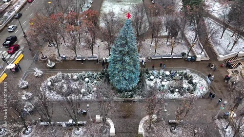 Drone aerial shot flying over Christmas tree in Millennium Park, Chicago on snowy winter day
