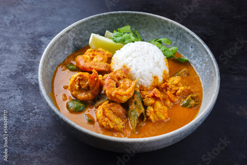 Traditional Thai kaeng phet red curry prawn with chili and basmati rice served as close-up in a Nordic design bowl