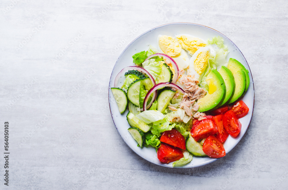 Tuna Salad, Healthy Food, Fresh Salad with Lettuce, Avocado, Cherries, Cucumber and Eggs on a Plate on Bright Background Tuna Salad, Healthy Food, Fresh Salad with Lettuce, Avocado, Cherries, Cucumber and Eggs on a Plate on Bright Background