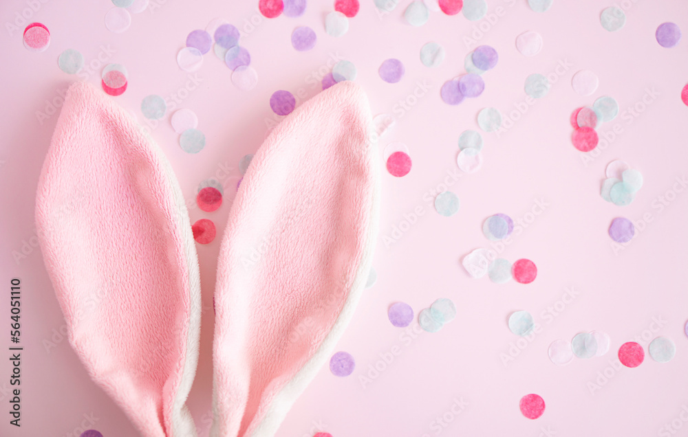 Easter greeting card .Pink bunny ears on pink pastel background wint confetti with, copy spase . Easter minimal concept. Flat lay. advertising concept . Easter greeting card .Pink bunny ears on pink pastel background wint confetti with, copy spase . Easter minimal concept. Flat lay. advertising concept .