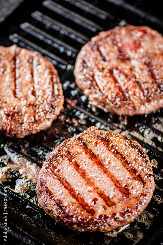Cooking a delicious grilled burger on a pan with oil bubbles. Cooking a delicious grilled burger on a pan with oil bubbles.