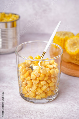 Glass with corn kernels on grey table