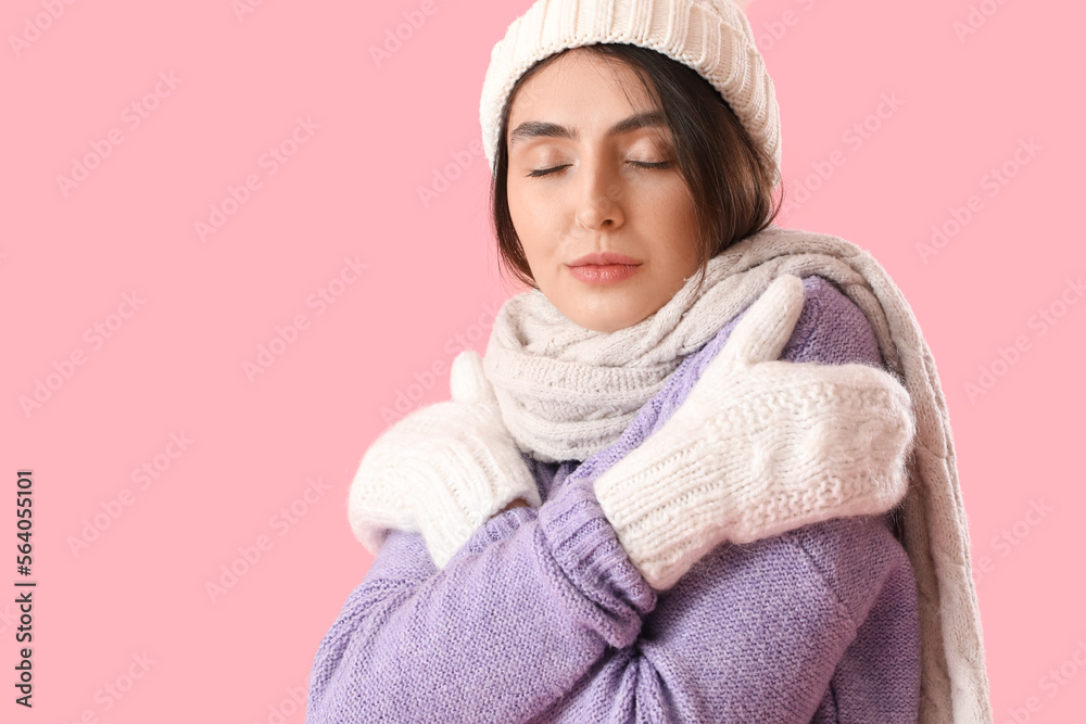 Frozen young woman in winter clothes on pink background, closeup Frozen young woman in winter clothes on pink background, closeup