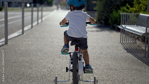 Fotografija Back of little boy riding bicycle outside