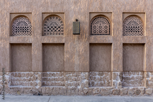 Arabic style window portals in stone wall with ornaments, traditional arabic architecture, Al Fahidi, Dubai, United Arab Emirates. photo