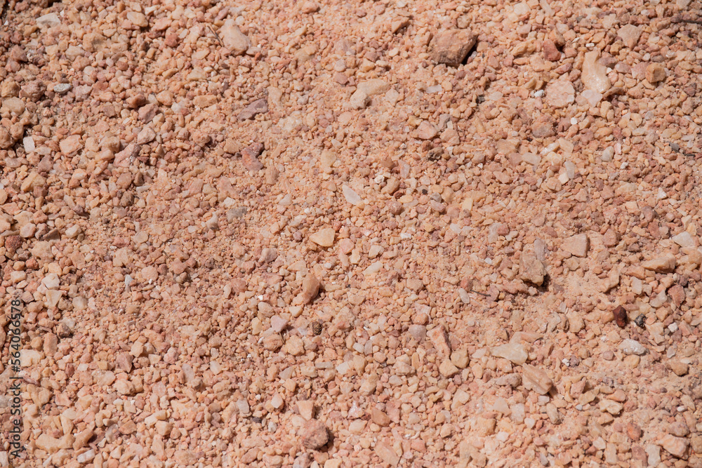Stone floor, typical of the Brazilian Cerrado. Texture of small beige stones. Round rocks, rocky ground. Background, backdrop, nature, characteristic of the Biome of Goiás.