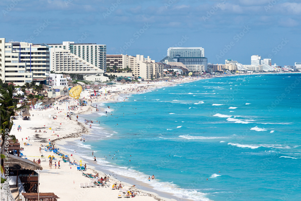 Cancun. Caribbean sea beach with turquoise water and white sand. Seaside resorts along the coastline. Travel destination