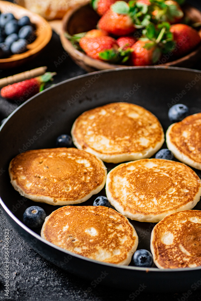 Pancakes in a frying pan with fresh berries. Pancakes in a frying pan with fresh berries.