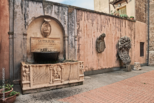 Sutri, Viterbo, Lazio, Italy: courtyard of the town hall with an ancient Roman sarcophagus used as a fountain and the coats of arms of the city and of Pope Urban VIII photo