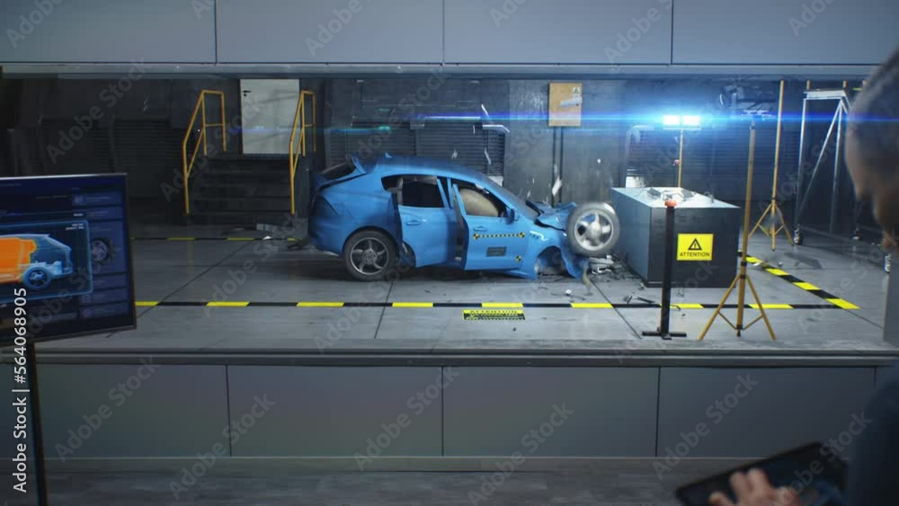 Male engineer simulates and watches process of traffic accident using digital tablet with modern system to change the safety parameters. 3D animation of electric car experimental crash test in lab.