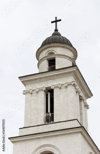 Upper part of church bell tower with a cross, an architectural structure in classical style photo