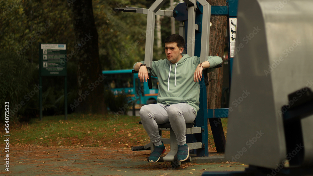 young man exercising in the park
athlete exercising on machine
