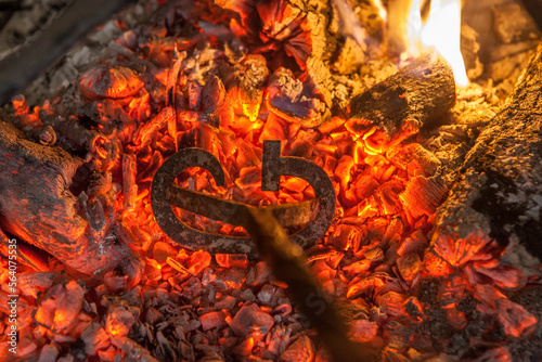 Branding iron for cattle over embers photo