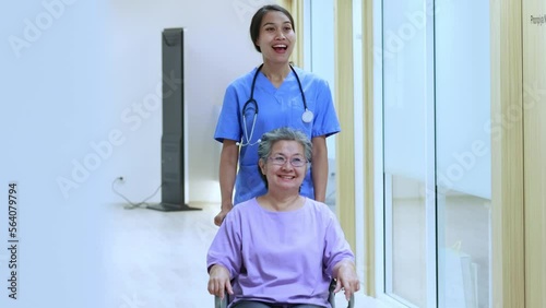 Asian female nurse pushing a senior female patient discharged from the hospital in a wheelchair