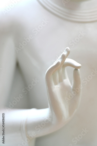 Hands of white stone Buddha in Buddhist temple